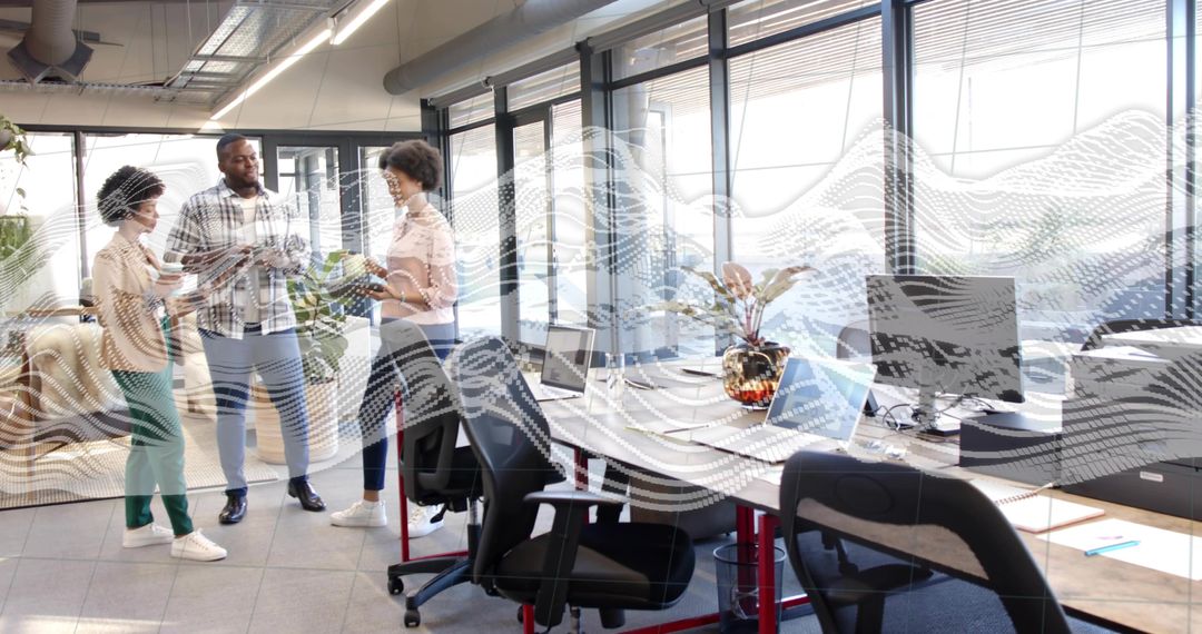 Collaborating Diverse Team Sharing Tablet and Papers in Bright Open-Plan Office Workspace