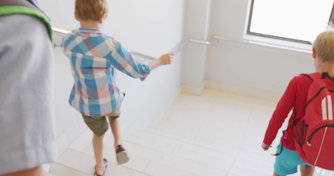 Children Adventurously Walking Downstairs in School Building