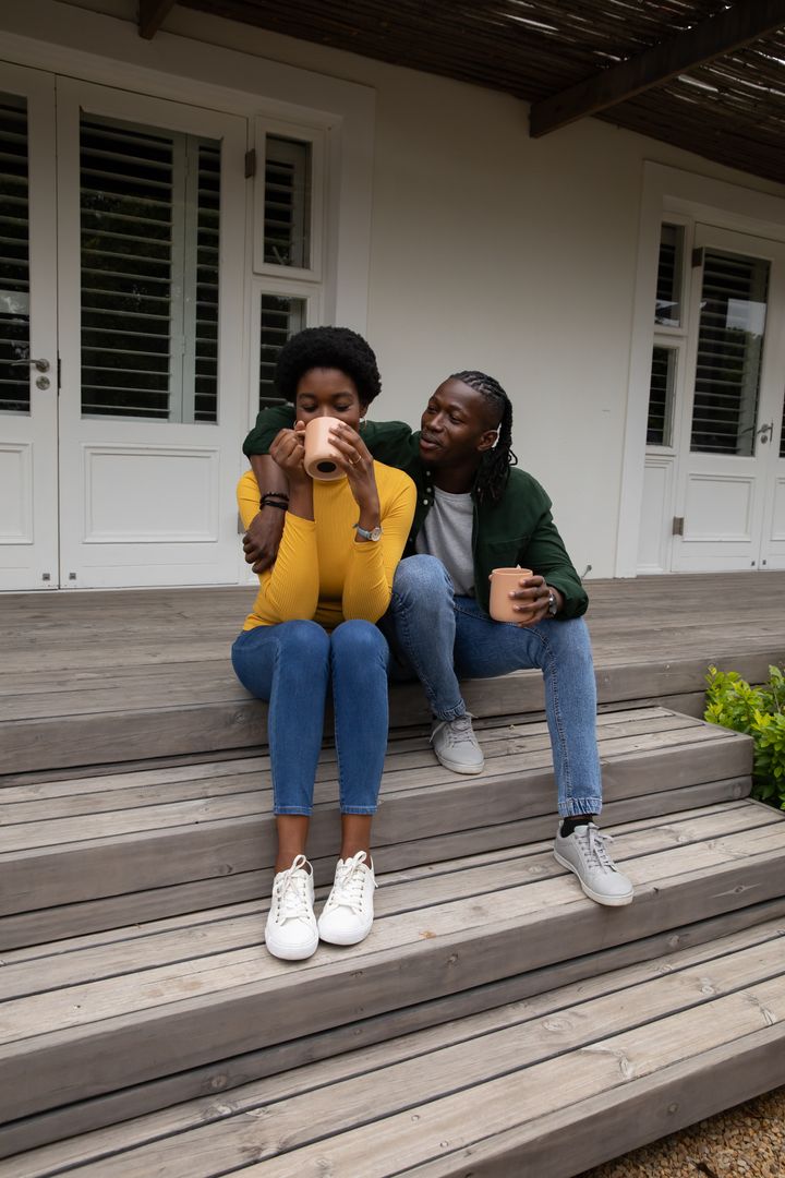 Couple Relaxing with Hot Drinks on Rustic Porch