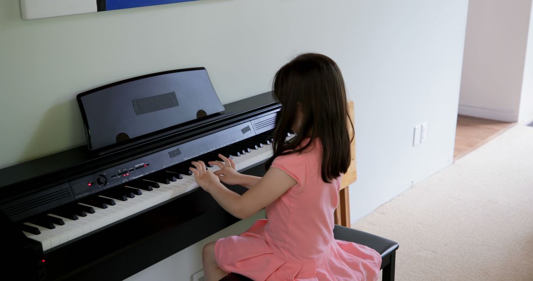 Young Girl in Pink Dress Practicing Piano - Free Images, Stock Photos and Pictures on Pikwizard.com