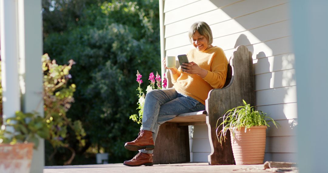 Senior Woman Relaxing on Porch Reading Book and Drinking Coffee - Free Images, Stock Photos and Pictures on Pikwizard.com