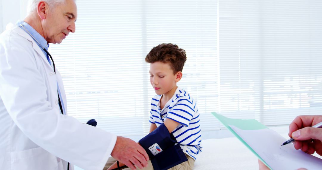 Doctor Measuring Blood Pressure of Young Boy in Clinic - Free Images, Stock Photos and Pictures on Pikwizard.com