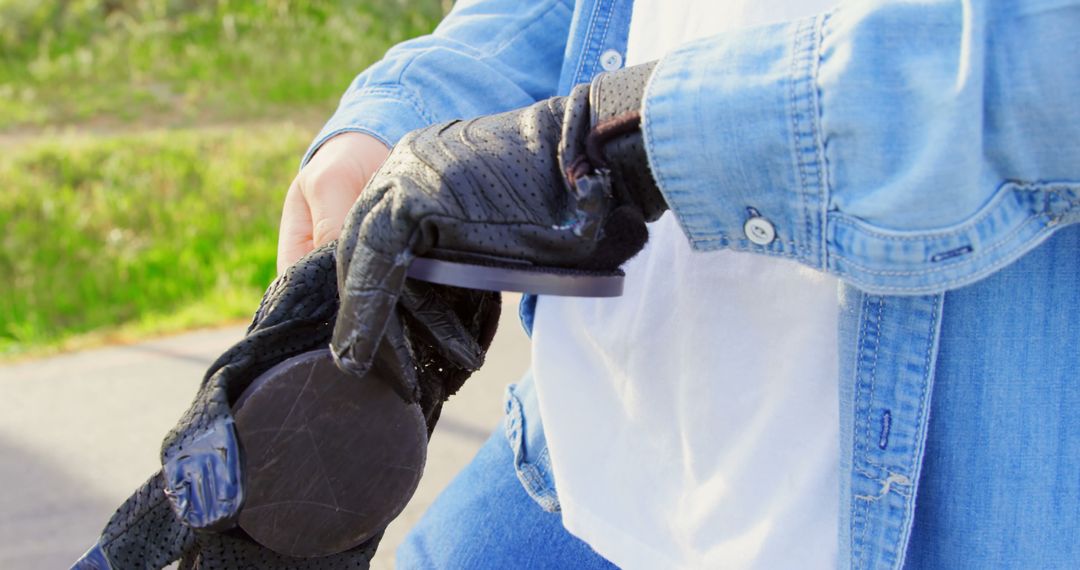 Person Putting On Protective Glove Outdoors - Free Images, Stock Photos and Pictures on Pikwizard.com