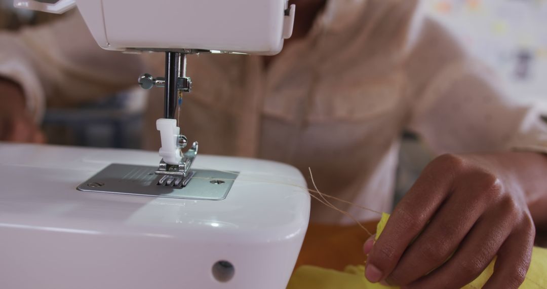 Close-Up of Person Using Sewing Machine on Yellow Fabric - Free Images, Stock Photos and Pictures on Pikwizard.com