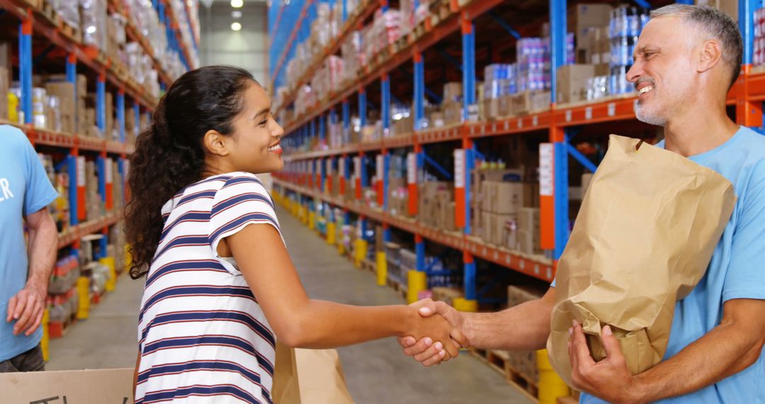 Volunteers in a Warehouse Distribution Center Shaking Hands - Free Images, Stock Photos and Pictures on Pikwizard.com