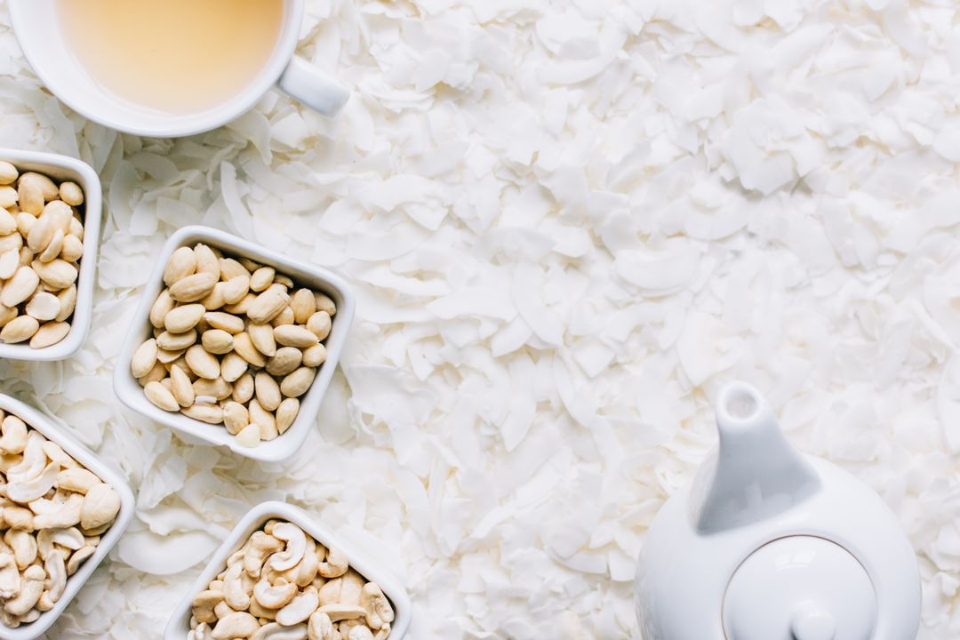 Healthy Snacking with Cashews and Tea on Coconut Flakes Background