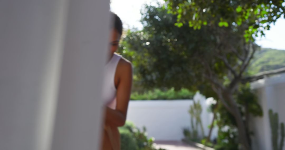 Elegant Woman Peeking Around Garden Pillar