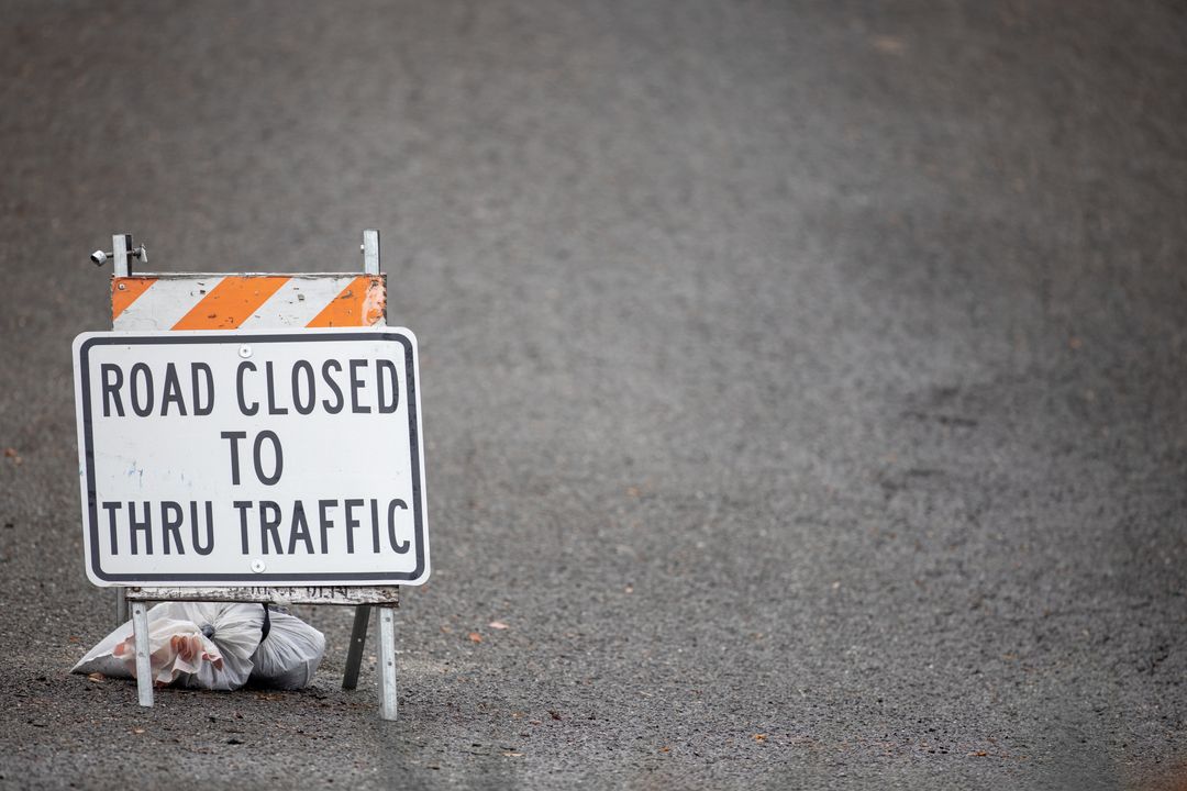 Road Closed Sign Sitting on Empty Asphalt