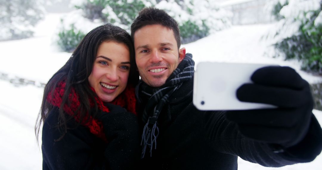 Happy Couple Taking Selfie in Snowy Winter Wonderland - Free Images, Stock Photos and Pictures on Pikwizard.com