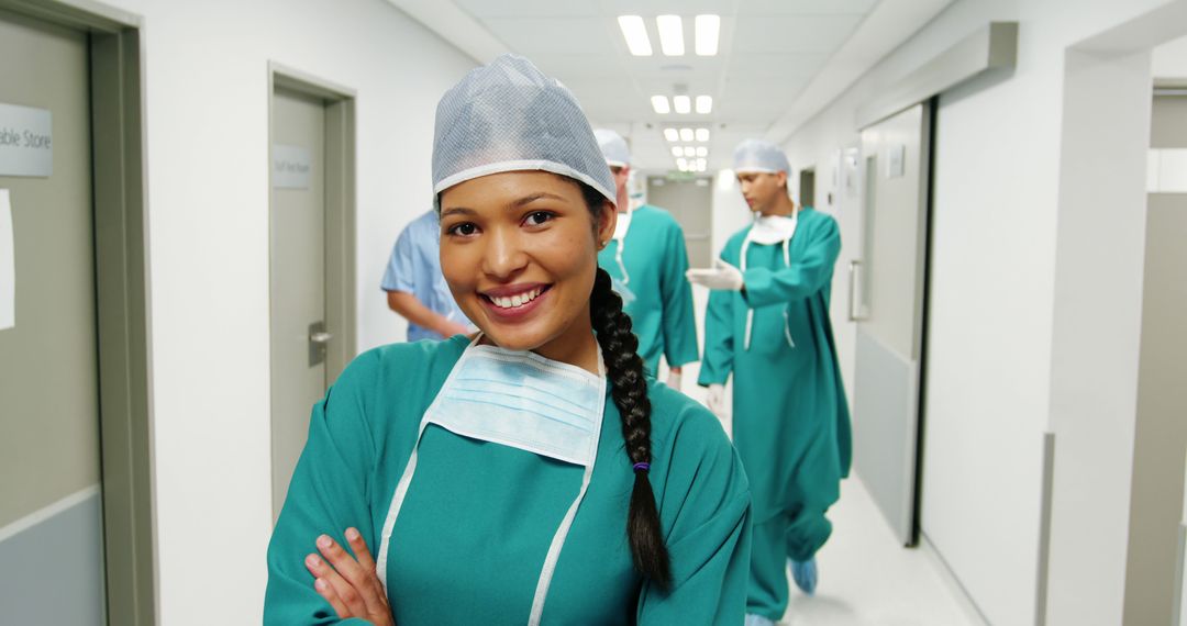 Confident Surgeon Smiling in Hospital Hallway with Medical Team - Free Images, Stock Photos and Pictures on Pikwizard.com