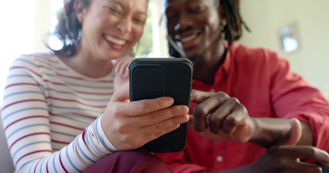 Two Friends Laughing and Watching Video on Smartphone - Free Images, Stock Photos and Pictures on Pikwizard.com