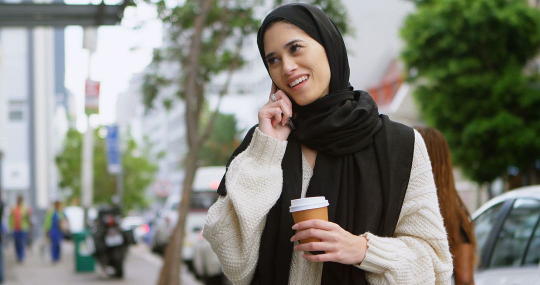 Smiling Woman in Hijab Talking on Mobile Phone Outdoors - Free Images, Stock Photos and Pictures on Pikwizard.com