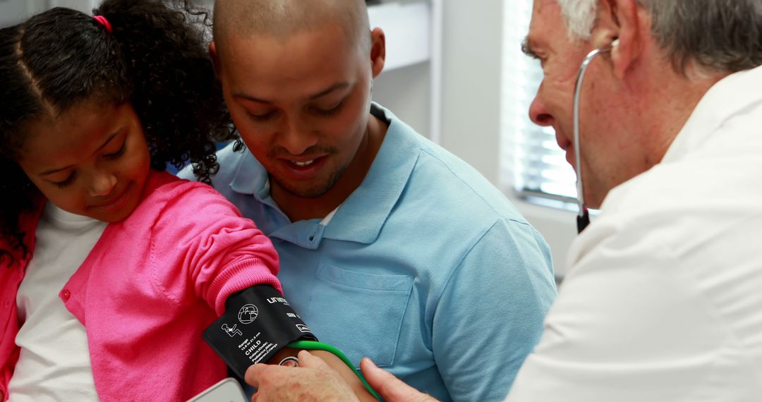 Doctor Taking Blood Pressure of Young Girl While Her Father Watches - Free Images, Stock Photos and Pictures on Pikwizard.com