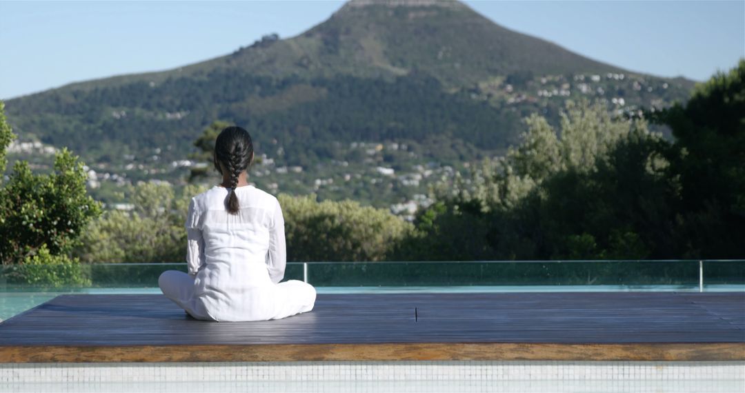 Woman in white practicing meditation on outdoor platform - Free Images, Stock Photos and Pictures on Pikwizard.com