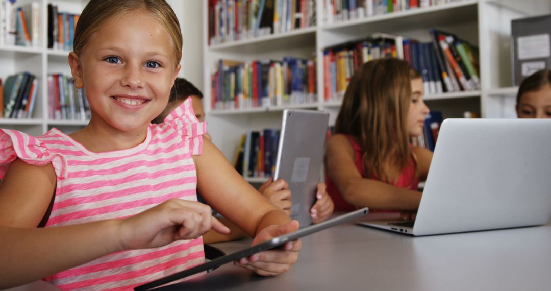 Smiling Girl Using Tablet in Classroom with Other Young Students - Free Images, Stock Photos and Pictures on Pikwizard.com