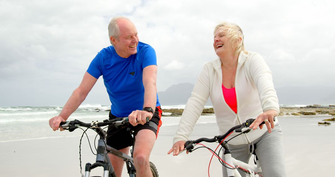 Senior Couple Biking Along Beach Smiling and Enjoying Outdoor Activity - Free Images, Stock Photos and Pictures on Pikwizard.com