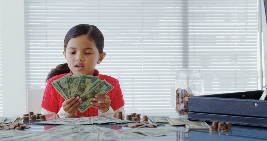 Child Counting Money at Table with Coins and Bills - Free Images, Stock Photos and Pictures on Pikwizard.com