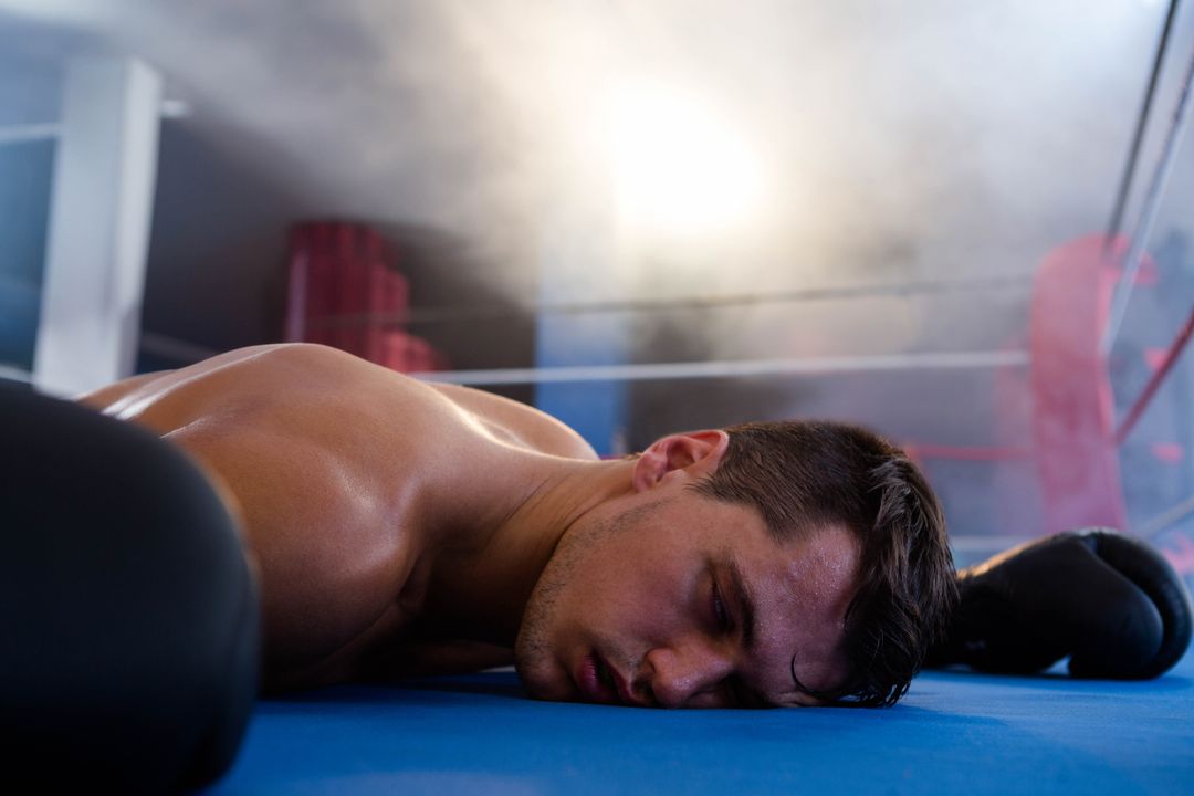 Defeated Boxer Lying in Ring under Arena Lights