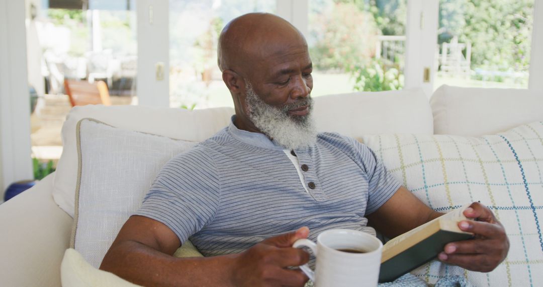 Senior Man Relaxing Indoors with Book and Coffee - Free Images, Stock Photos and Pictures on Pikwizard.com