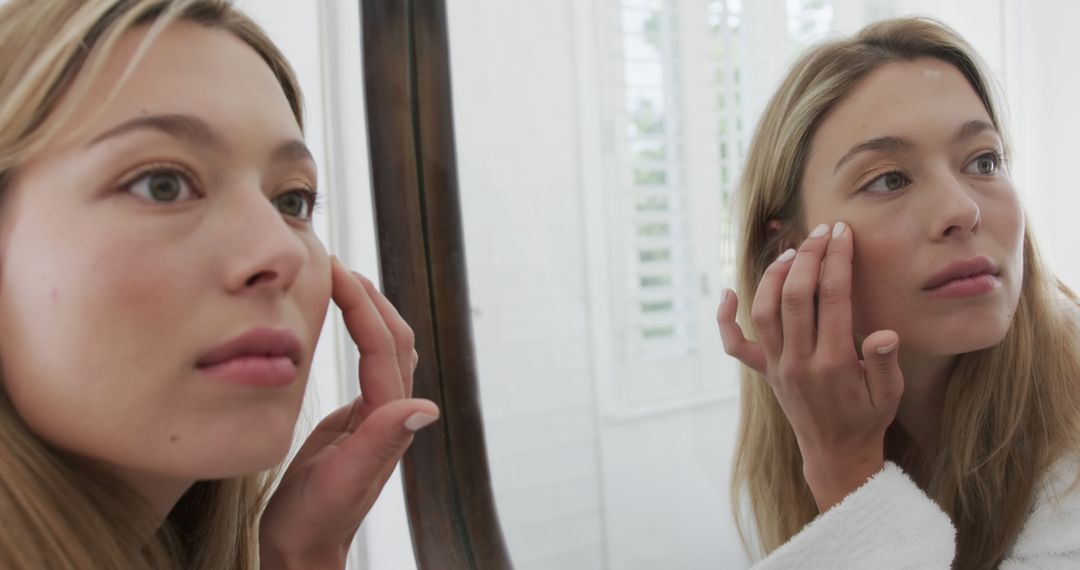 Young Woman Examining Skin Condition in Mirror Inside Bathroom - Free Images, Stock Photos and Pictures on Pikwizard.com