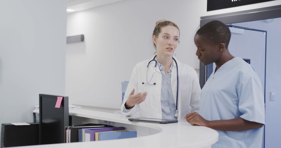 Healthcare Professionals Discussing Patient Records at Reception Desk - Free Images, Stock Photos and Pictures on Pikwizard.com