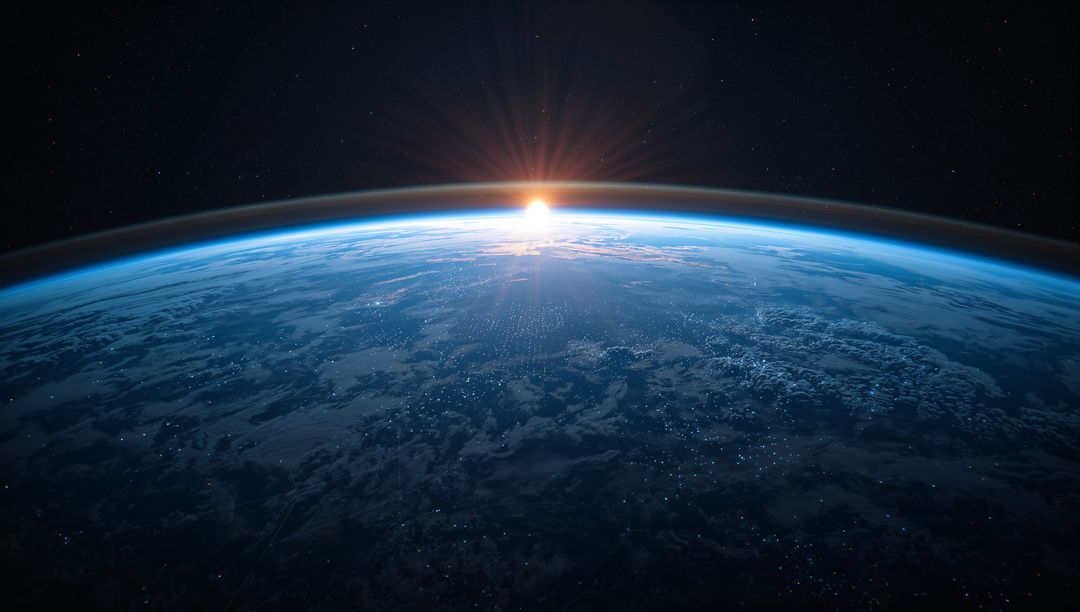 Sun Rising Over Earth from Low Orbit Showing Blue Atmospheric Halo and City Lights