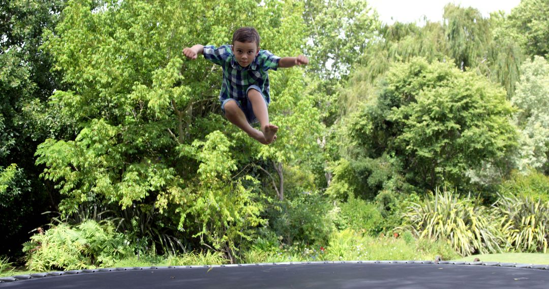 Child Jumping on Trampoline in Garden - Free Images, Stock Photos and Pictures on Pikwizard.com