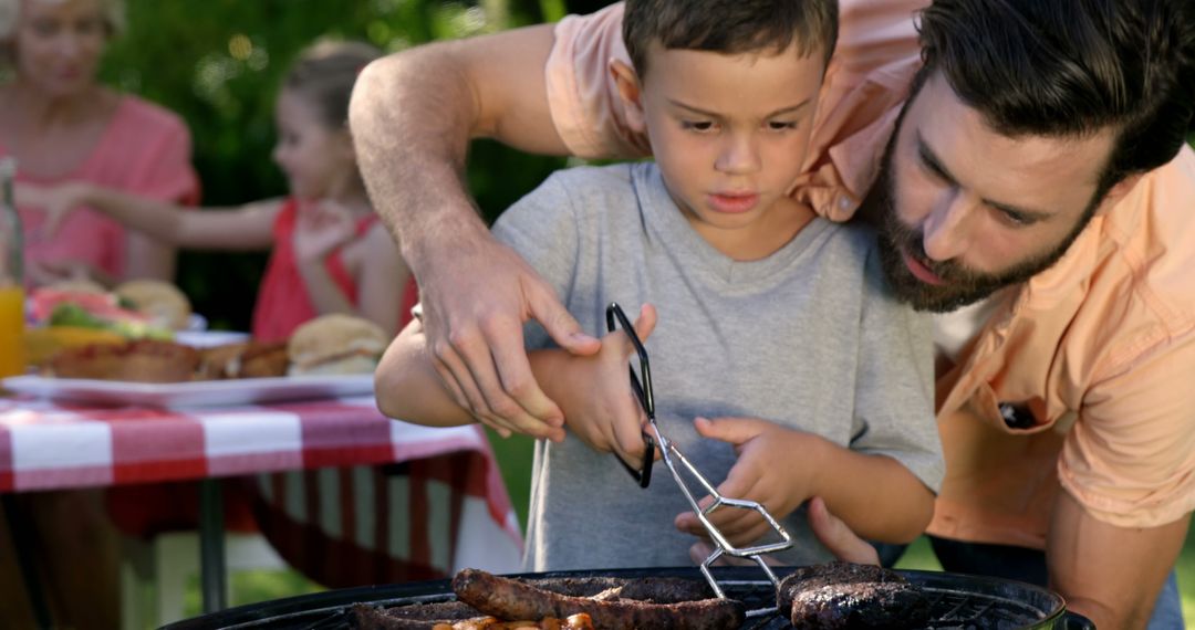 Father and Son Grilling Meat at Family Barbecue - Free Images, Stock Photos and Pictures on Pikwizard.com