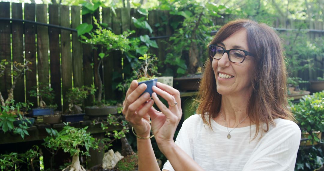 Woman Appreciating Tiny Plant in Lush Garden - Free Images, Stock Photos and Pictures on Pikwizard.com