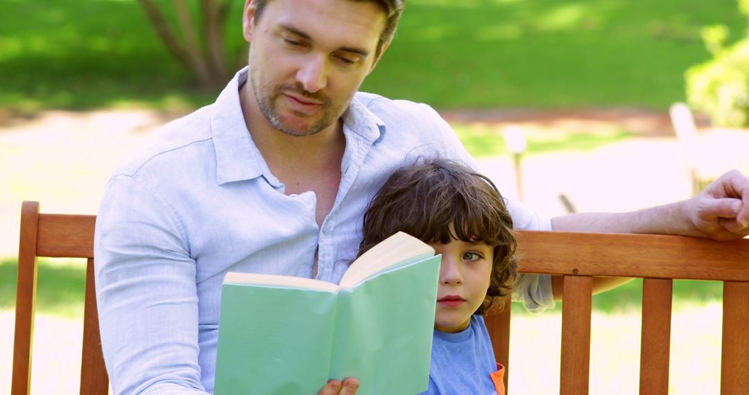 Father Reading Book with Son Outdoors on Park Bench - Free Images, Stock Photos and Pictures on Pikwizard.com