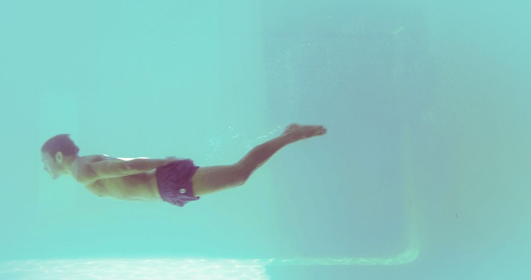 Man Swimming Underwater in Pool with Clear Blue Water - Free Images, Stock Photos and Pictures on Pikwizard.com