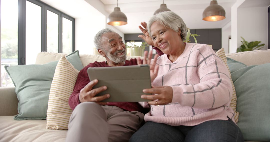 Seniors Enjoy Video Call on Tablet Couch at Home