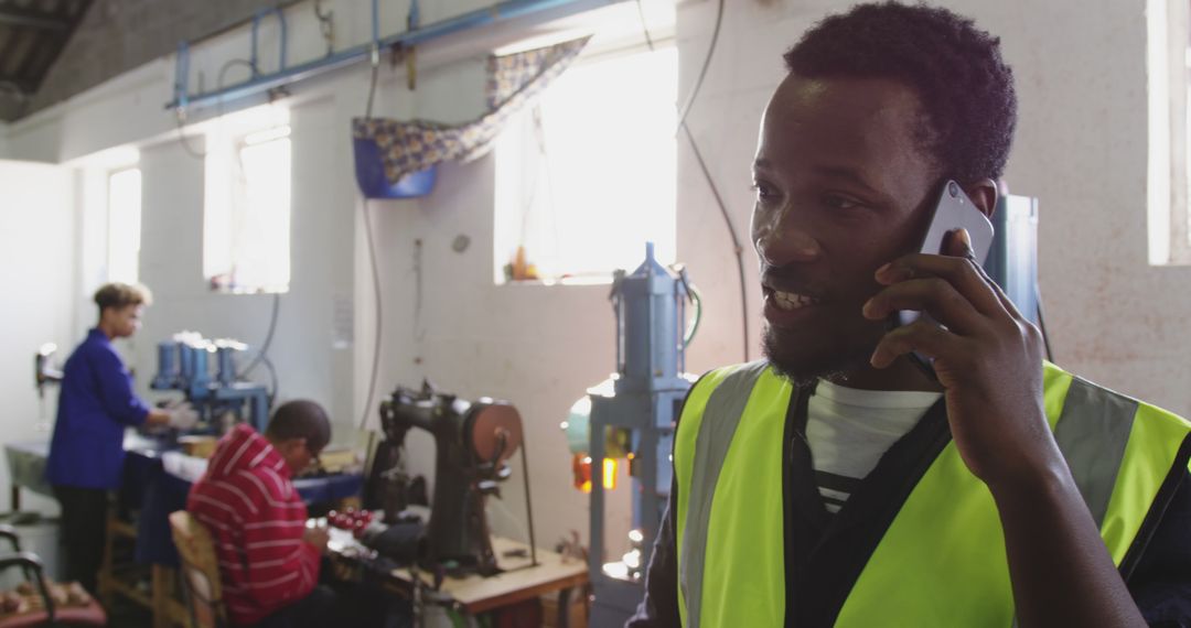 Factory Worker Talking on Phone in Industrial Setting - Free Images, Stock Photos and Pictures on Pikwizard.com