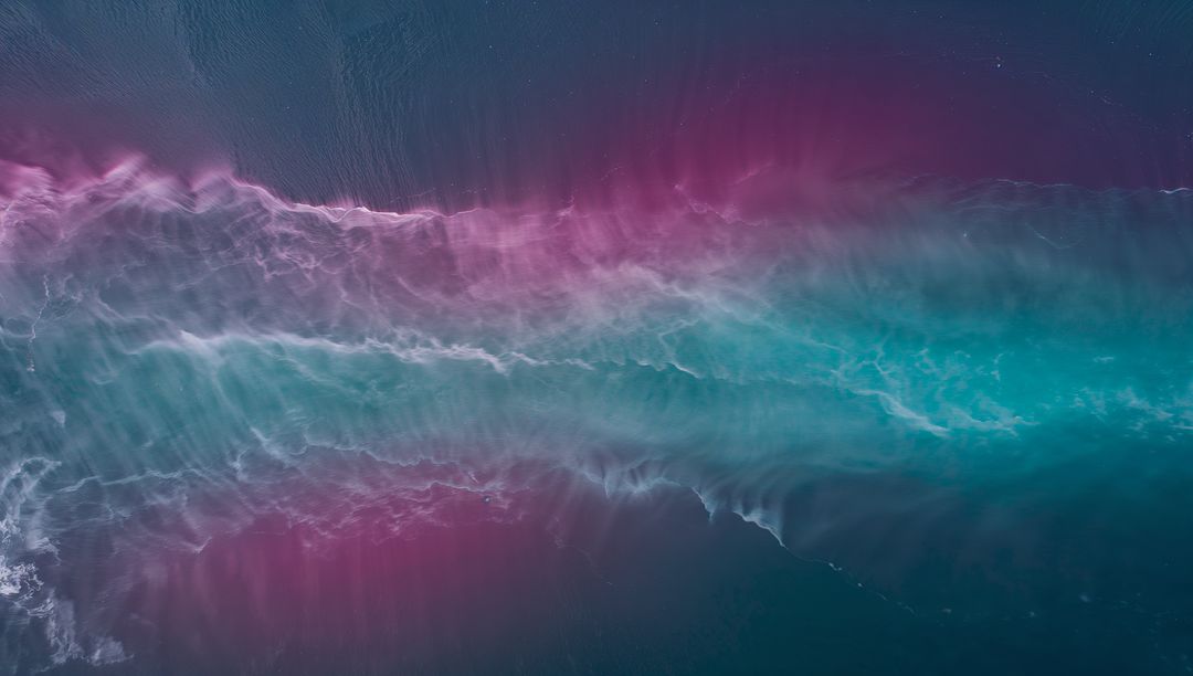 Aerial Turquoise Magenta Wave Band Flowing with Foamy Crest and Gradient Ocean Motion