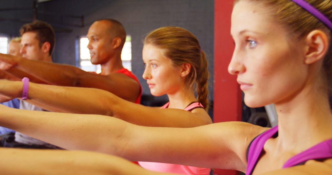 Group of Focused Individuals in Fitness Class Holding Arm Stretch - Free Images, Stock Photos and Pictures on Pikwizard.com