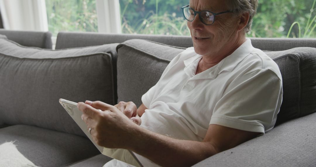 Senior Man Relaxing on Couch Using Tablet at Home - Free Images, Stock Photos and Pictures on Pikwizard.com