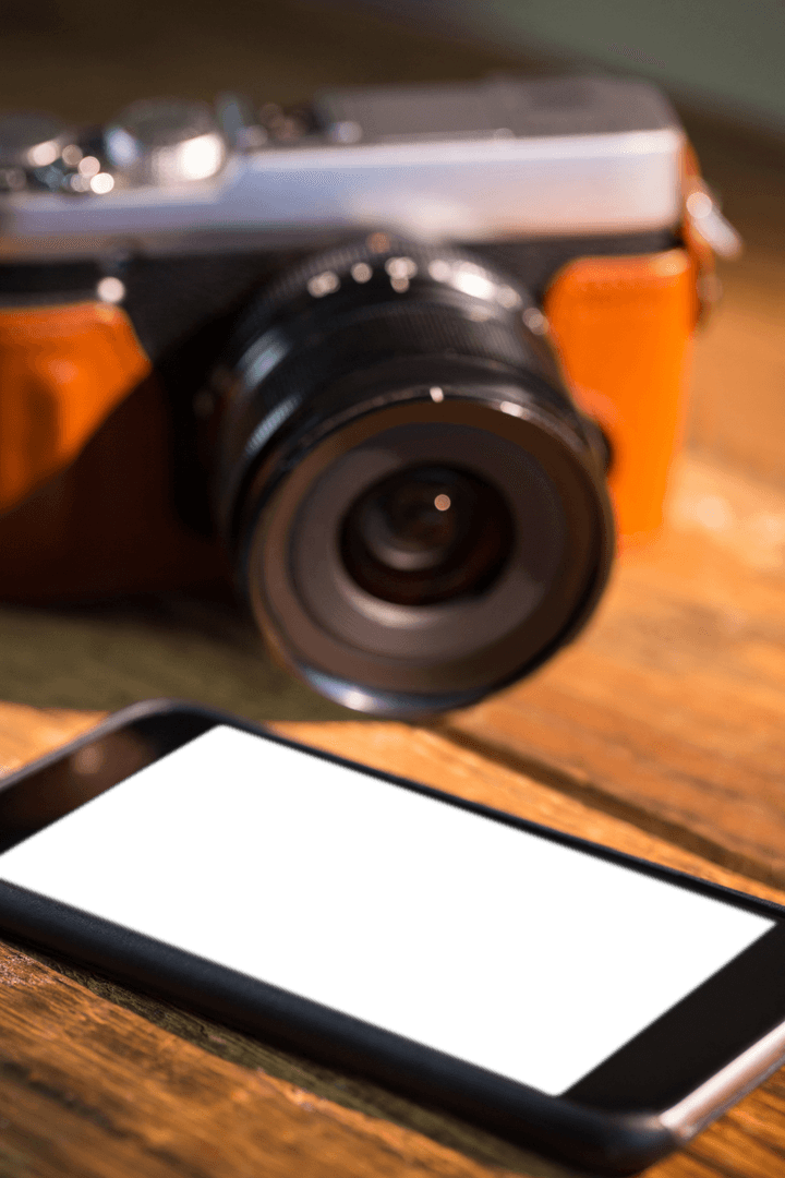 Transparent Smartphone and Vintage Camera on Wooden Surface