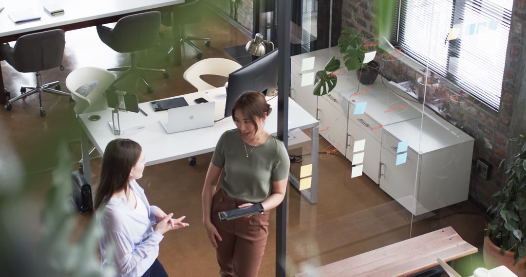 Two Women Communicating in Modern Office Startup Environment