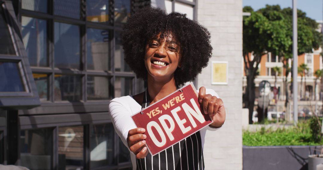 Happy Small Business Owner Displaying Open Sign Outside Café