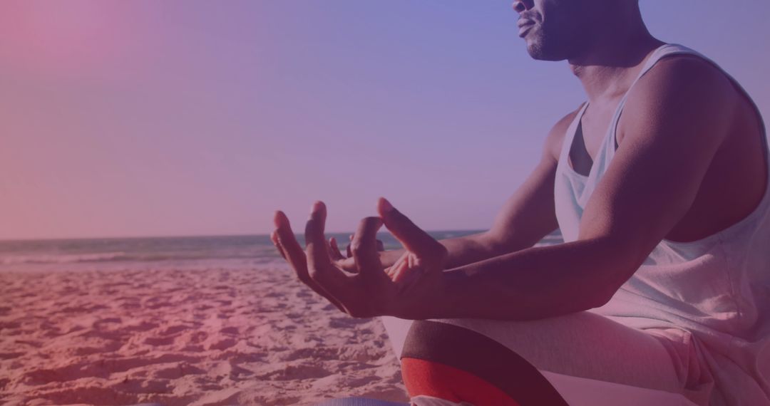 Man Meditating on Beach at Sunset