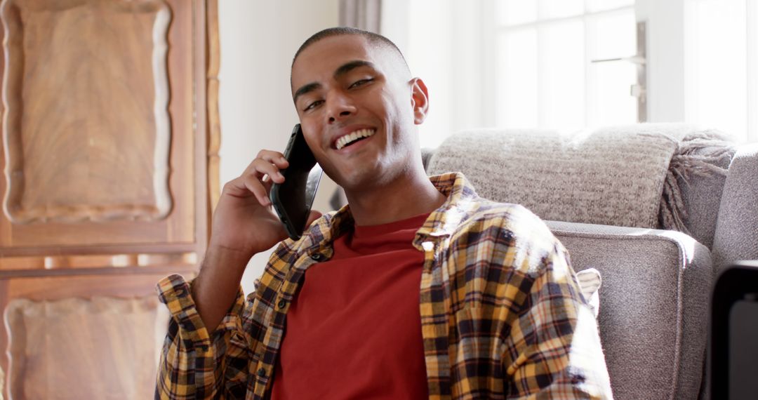 Smiling Man Talking on Smartphone While Relaxing at Home - Free Images, Stock Photos and Pictures on Pikwizard.com