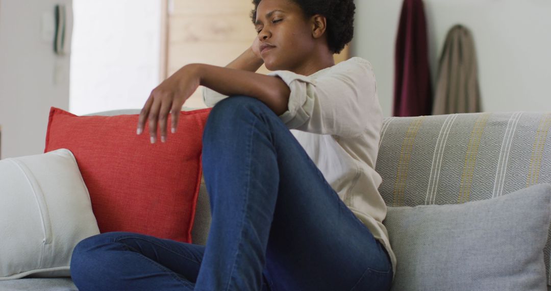 Stressed African American Woman Sitting on Couch at Home - Free Images, Stock Photos and Pictures on Pikwizard.com