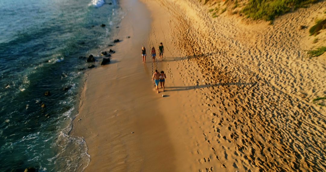 Group of Friends Walking on Sandy Beach at Sunset - Free Images, Stock Photos and Pictures on Pikwizard.com