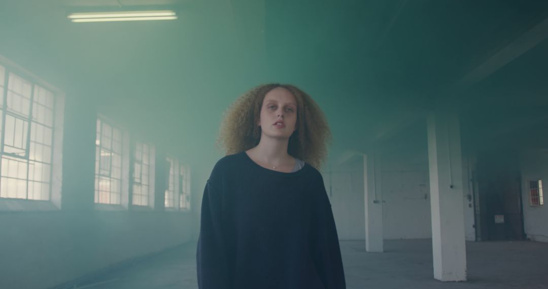 Woman Standing in Industrial Warehouse with Green Smoke - Free Images, Stock Photos and Pictures on Pikwizard.com