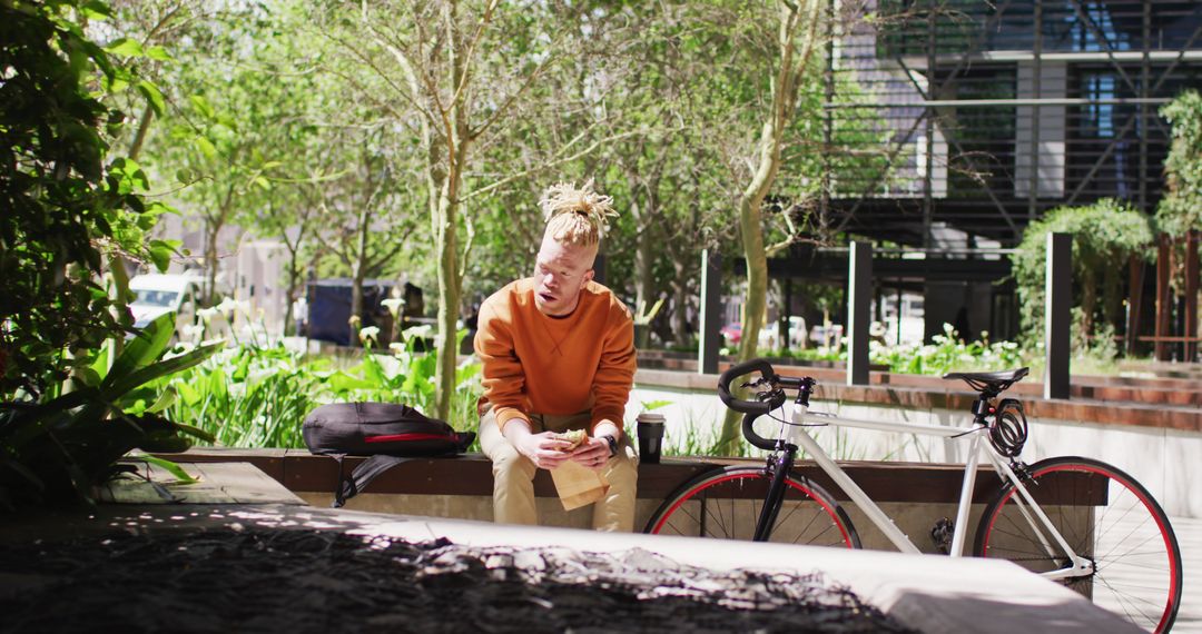 Man Relaxing in Park with Bicycle Eating Sandwich