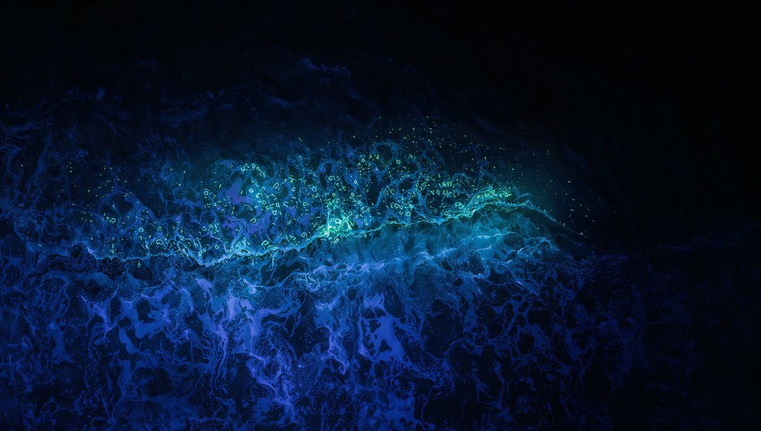 Glowing Turquoise Wave Stretching Across Night Ocean with Luminescent Foam and Specks