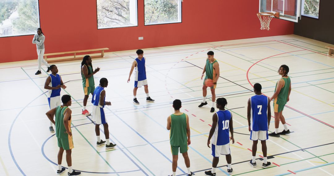 Diverse Male Basketball Team Practicing Strategies in Gymnasium