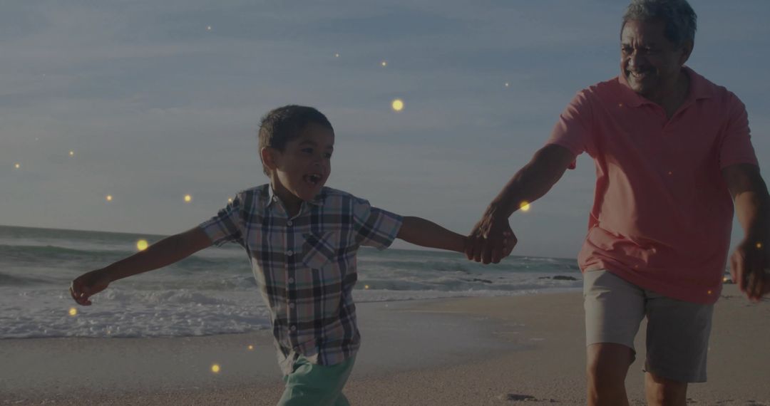 Grandfather and Grandson Running on Beach with Golden Glow