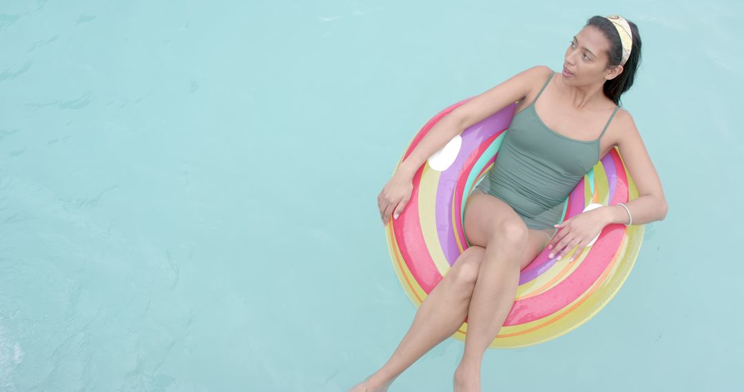 Woman Relaxing on Colorful Pool Float in Summertime