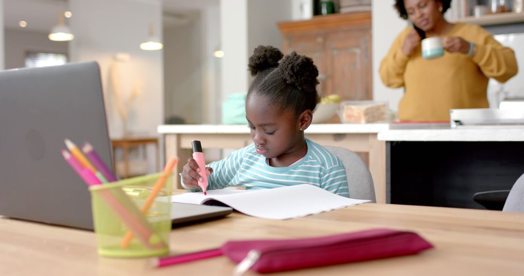 Focused African American Girl Doing Homework with Parent in Background - Free Images, Stock Photos and Pictures on Pikwizard.com